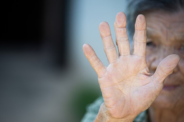 Close up picture of old woman's hand showing anti symbol