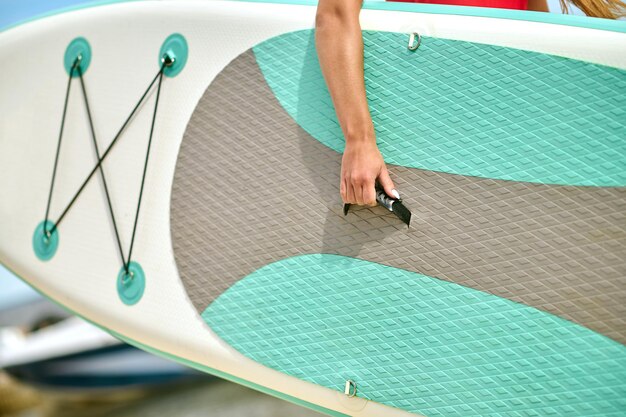 Close up picture of a person carrying the surfing board