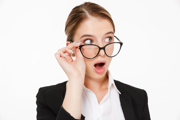 Close up picture of shocked blonde business woman in eyeglasses looking away over white 