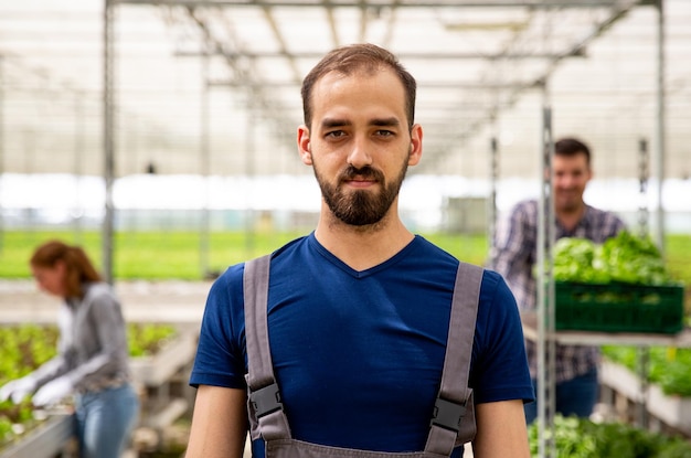 Close up pictures of a young farmer in the greenhouse. Satisfied face