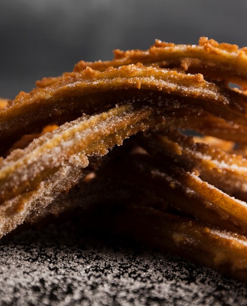 Close-up pile of fried churros and sugar