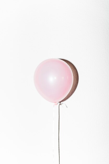 Close-up of pink balloon with shadow isolated on white background