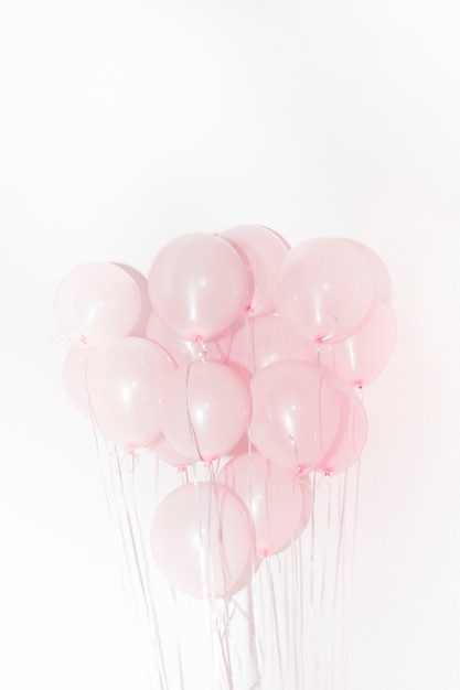 Close-up of pink balloons for birthday decoration against white backdrop