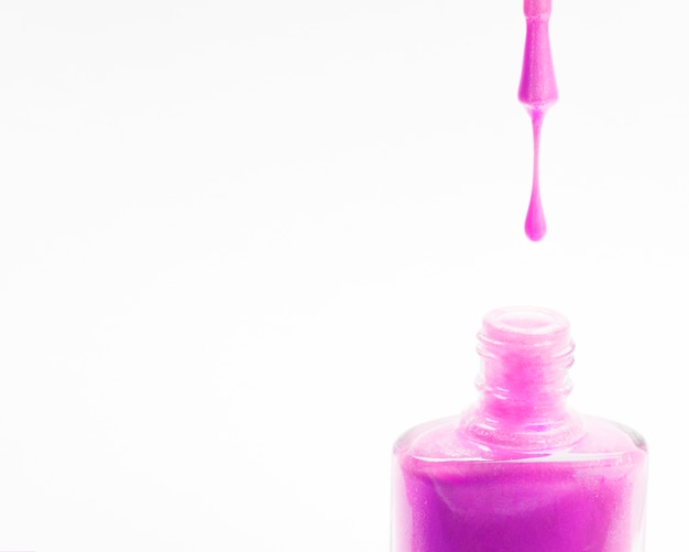 Close-up of pink nail polish with brush with copy space background