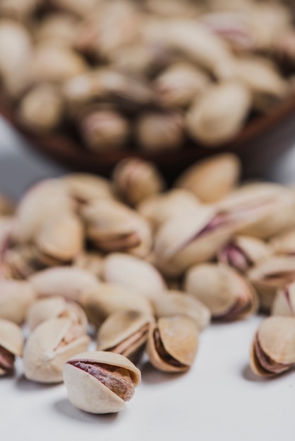 Close-up pistachios spilled near bowl