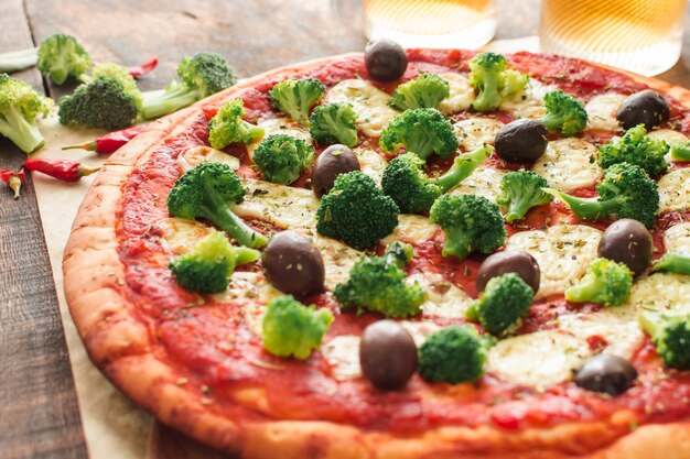 Close-up of pizza with tomato sauce; broccoli and olives and cheese