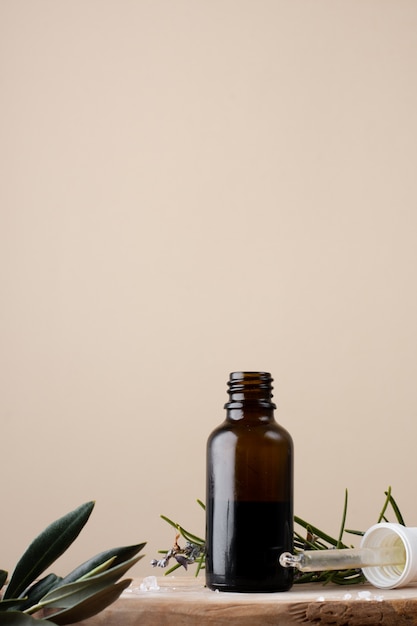 Close-up plastic bottle with oil and rosemary