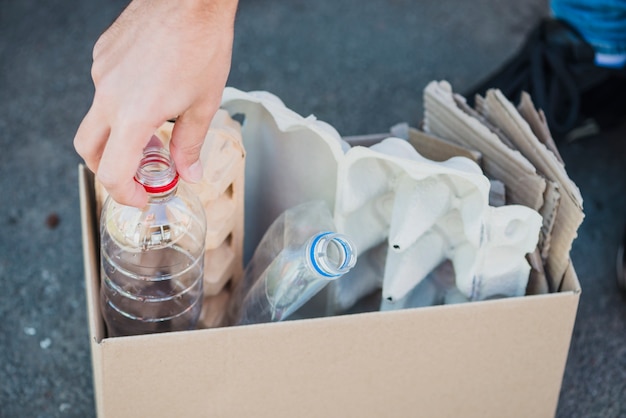 Foto gratuita primo piano delle bottiglie di plastica e del cartone dell'uovo nella scatola