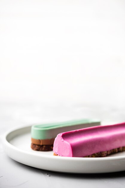 Close-up plate with blue and pink eclairs