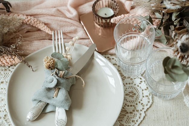 Close up of a plate with cutlery, decorated with dry flowers in a rustic style.