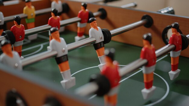 Close up of players on foosball game table for fun activity in office after work. Table with football game play to score goal for entertainment with workmates after hours. Soccer amusement