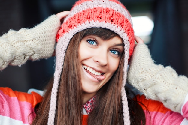 Close-up of playful girl biting her tongue with hands on head