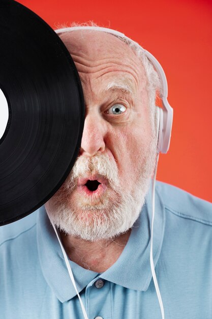 Close-up playful senior with music record