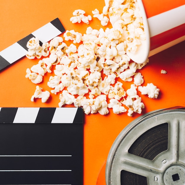 Free photo close-up popcorn near clapperboard and film bobbin