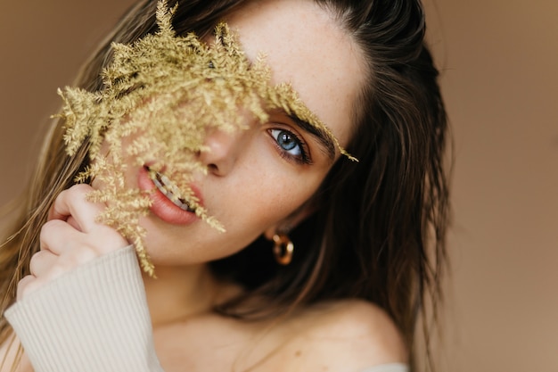 Ritratto del primo piano dell'adorabile modello femminile con i capelli neri. attraente donna bruna con interesse.