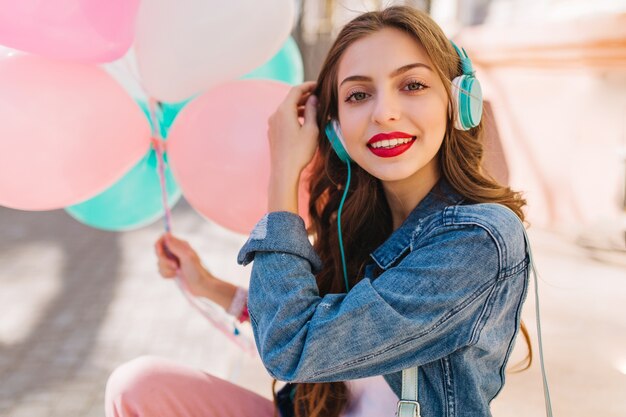 Close-up portrait of adorable smiling girl wearing denim jacket having fun at the birthday party.