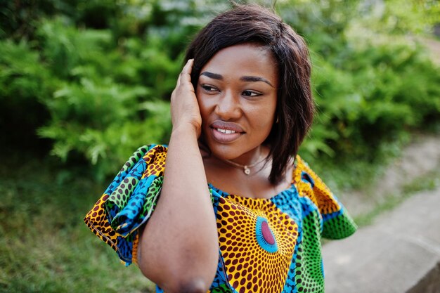 Close up portrait of african american girl in coloured shirt sitting outdoor Fashionable black woman