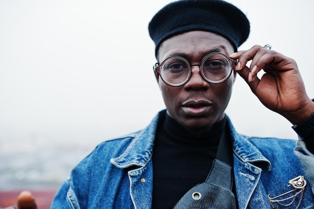 Close up portrait of african american man in jeans jacket beret and eyeglasses