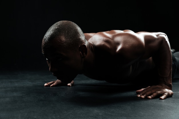 아름다운 근육질의 몸이 바닥에 팔 굽혀 펴기 운동을하는 아프리카 계 미국인 스포츠 남자의 클로즈 업 초상화