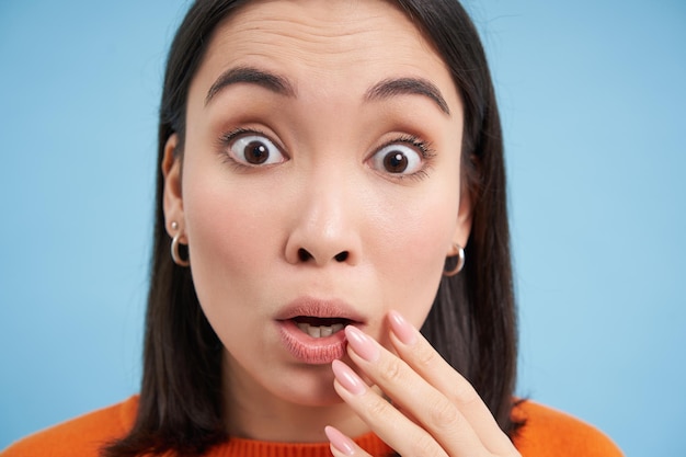 Free photo close up portrait of amazed asian girl looks with interest listens to amazing story impressed by som