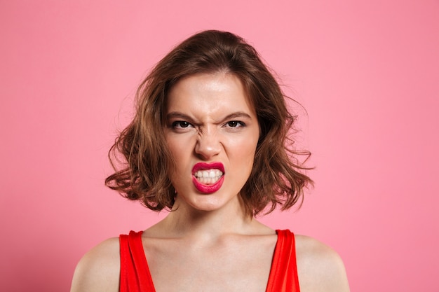 Close-up portrait of angry young woman with red lips 