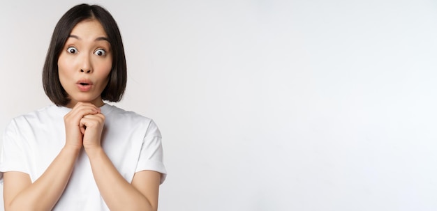 Free photo close up portrait of asian brunette woman looking amazed say wow watching smth impressive standing o