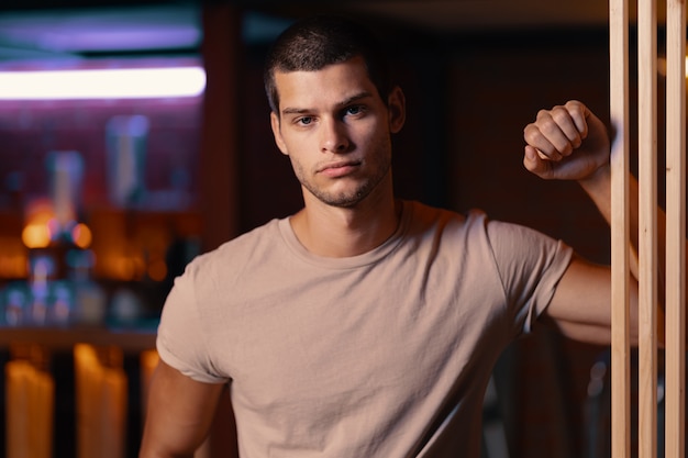 Close-up portrait of attractive male model. Young handsome man in a bar