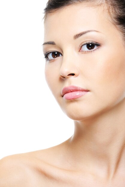 Close-up portrait of a attractive serene asian female face over white