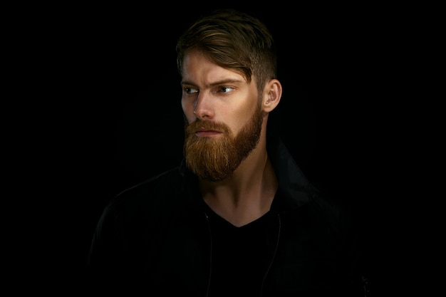 Close-up portrait of bearded handsome man in a pensive mood looking away