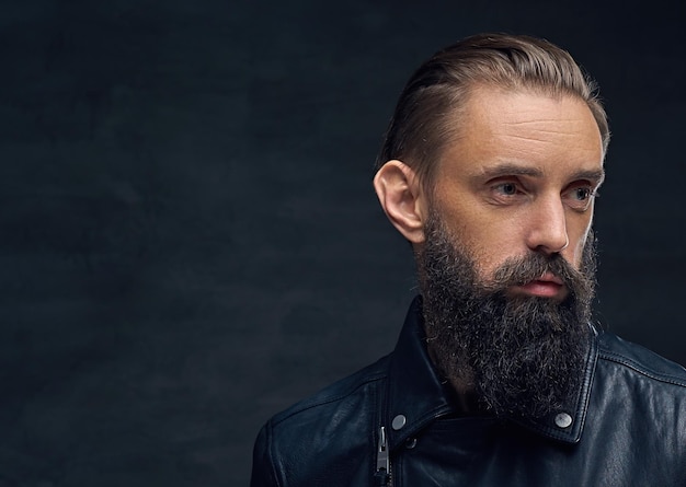 Close up portrait of bearded male wearing black leather jacket.