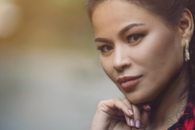 Foto gratuita ritratto del primo piano di bella donna asiatica adulta all'aperto. la donna matura sta guardando seriamente.