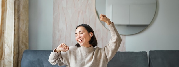 Free photo close up portrait of beautiful asian girl dancing feeling happy and upbeat listening music in