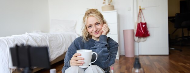 Free photo close up portrait of beautiful blond woman girl sits in her room does makeup records video for