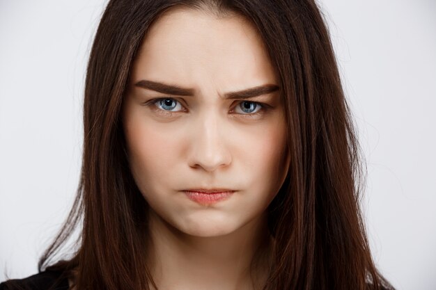 Close up portrait of beautiful brunette girl starring with anger