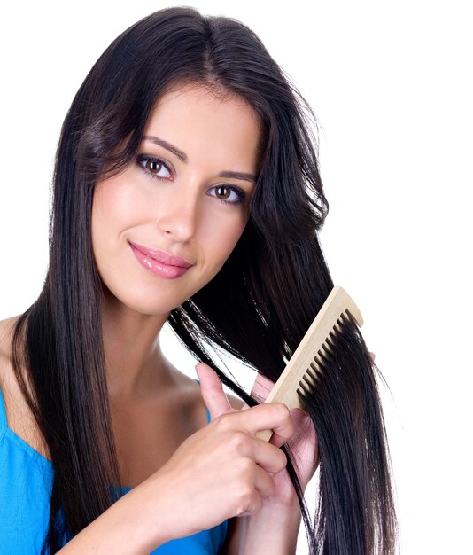 Close-up portrait of beautiful pretty woman with comb caring about her long hair - isolated