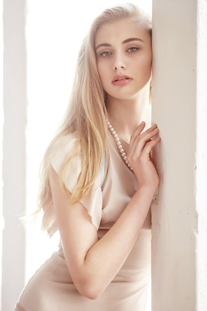 Close up portrait of beautiful slim female with long blond hair and red lips.