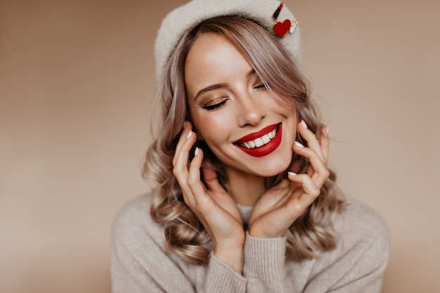 Close-up portrait of blissful blonde french woman with red lips