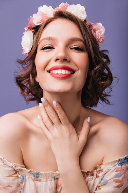 Макро портрет жизнерадостной женщины с модным маникюром и макияжем. улыбающаяся милая девушка в цветочном венке.