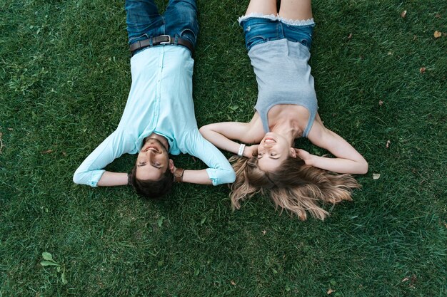 Крупным планом портрет беззаботной пары, лежа на траве вместе в любви