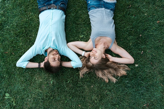 Foto gratuita chiuda sul ritratto di coppia spensierata sdraiato sull'erba insieme nell'amore