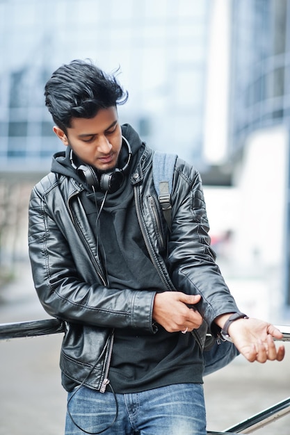 close up portrait of casual and stylish young asian man with earphones and backpack