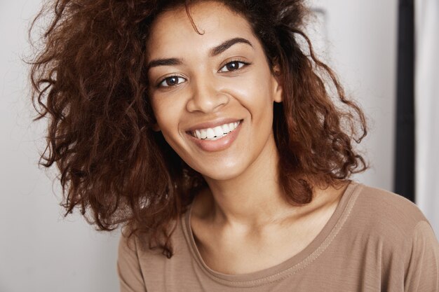 Close-up portrait of cheerful beautiful african girl smiling . Young woman happily facing her future,