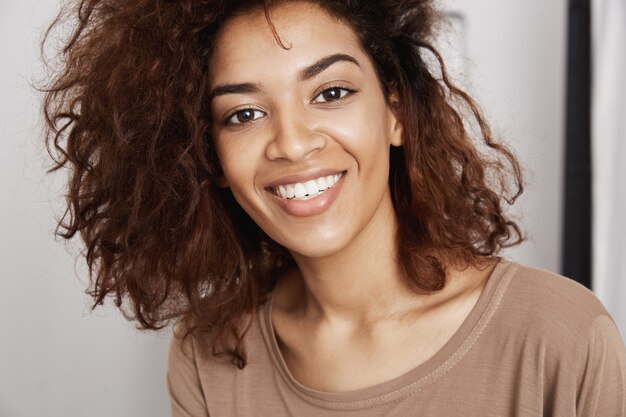 웃 고 밝고 아름 다운 아프리카 여자의 근접 초상화입니다. 젊은 여자가 행복하게 그녀의 미래에 직면