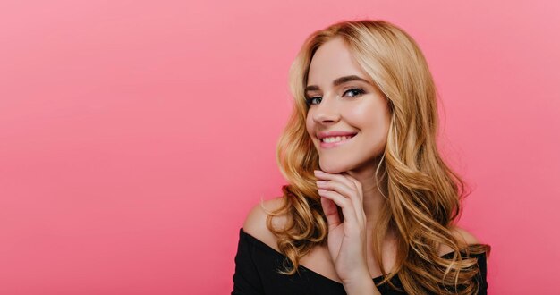 Close-up portrait of cheerful caucasian woman with blue big eyes. Romantic joyful girl with blonde hair posing with pleased smile.