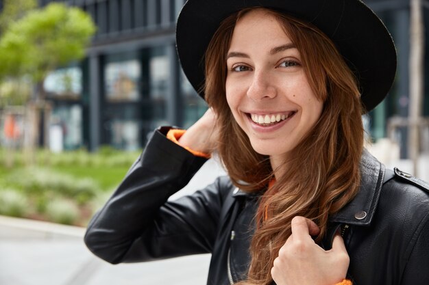 Close up portrait of cheerful traveler with pleasant appearance and toothy smile