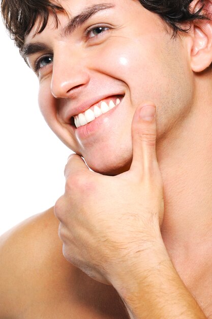 Close-up portrait of cleanshaven male face with a toothy smile