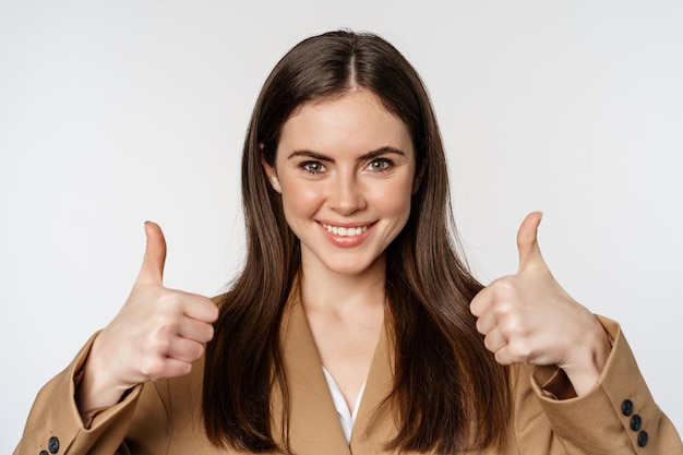 Free photo close up portrait of confident businesswoman smiling showing thumbs up recommending company complime...