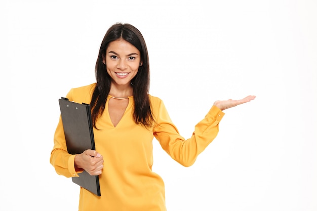 Close-up portrait of confident charming woman with folder showing empty palm