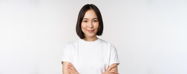 Close up portrait of confident korean girl student looking at camera with pleased smile arms crossed