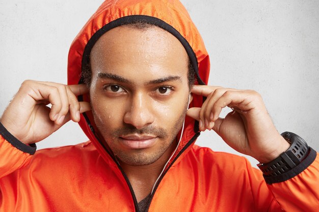 Close up portrait of confident male athlete covers long distance, being sweaty after exhausted training